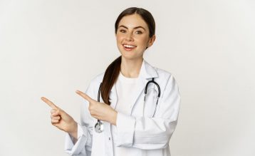 retrato-de-uma-jovem-sorridente-medica-profissional-de-saude-apontando-os-dedos-para-a-esquerda-mostrando-c-min